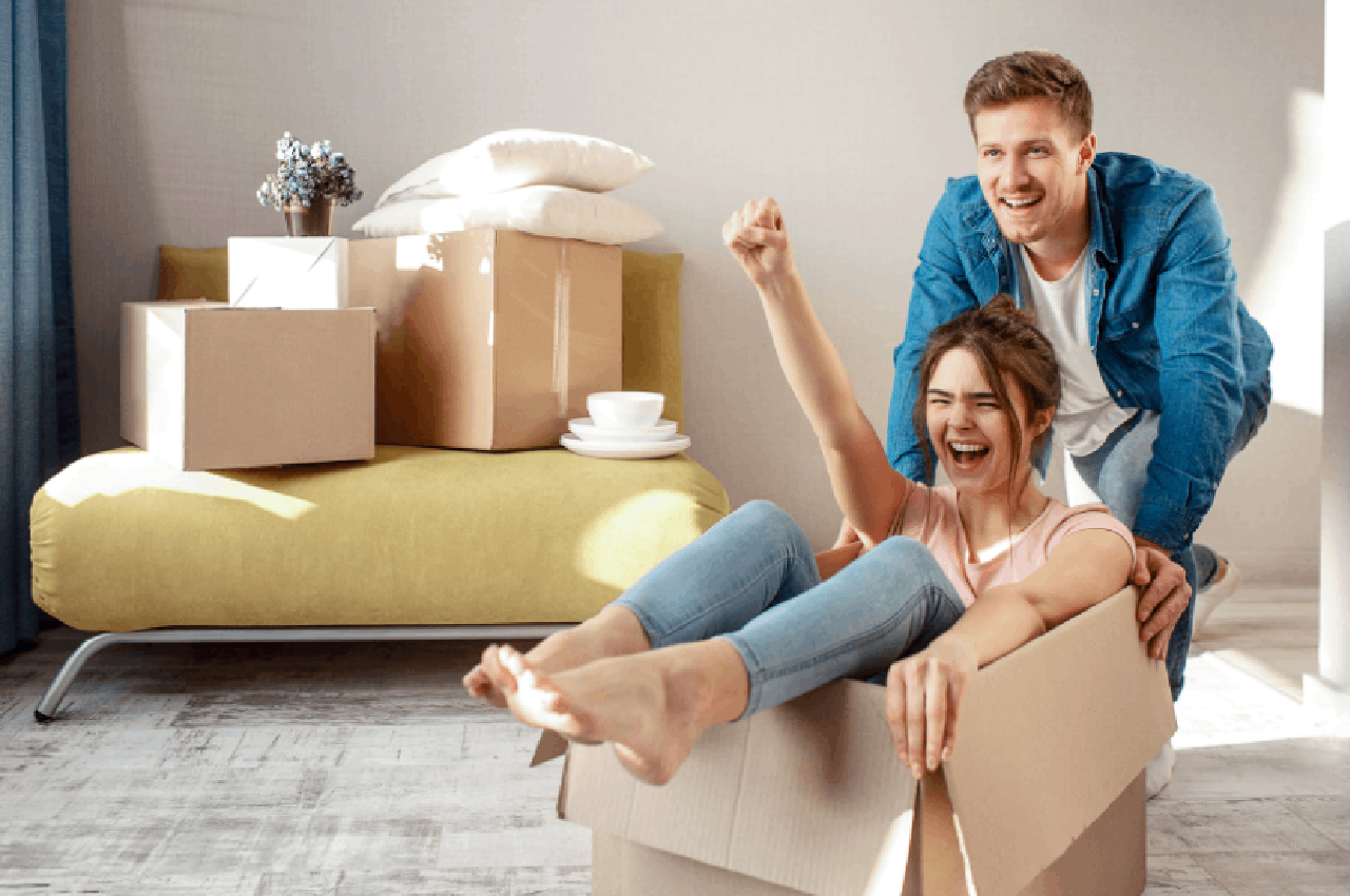 Coppia felice nella nuova casa dopo il trasloco, simbolo di una scelta consapevole del canone di affitto