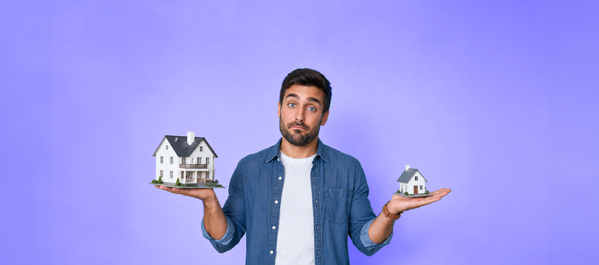 Uomo confronta due modelli di abitazione di dimensioni diverse, rappresentando la scelta tra affitto medio termine vs breve nel mercato immobiliare.