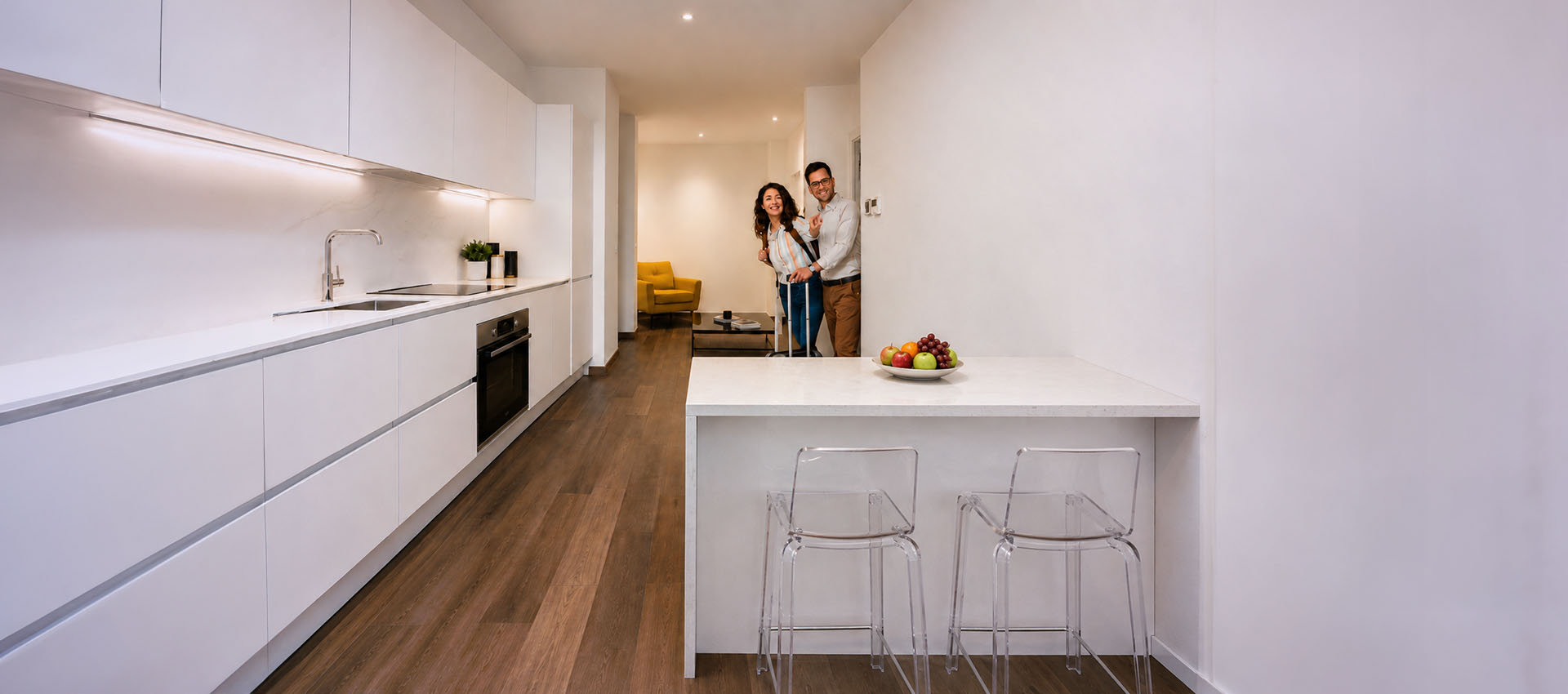 Come deve essere consegnato un appartamento in affitto: inquilini con valigia entrano nella casa con cucina moderna e pulita.