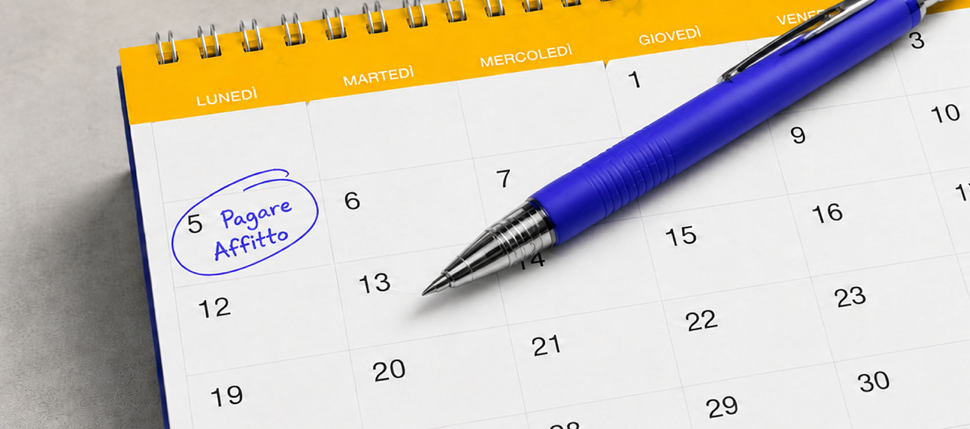 Penna blu su un calendario mensile con il promemoria 