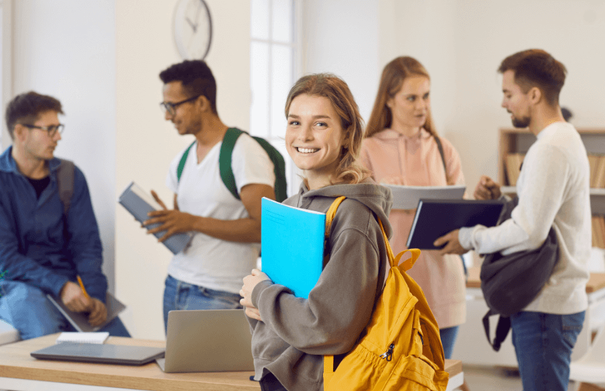 Ragazza studentessa in primo piano con un quaderno in mano, simbolo della ricerca e firma di un contratto di affitto per studenti stranieri 