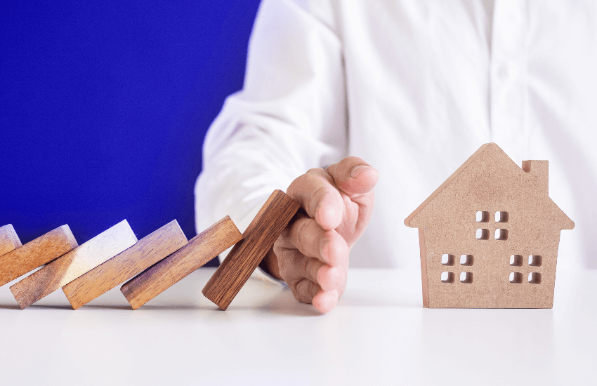 Protezione dell’affitto tramite fideiussione bancaria, illustrata con una mano che impedisce a una casa in miniatura di cadere