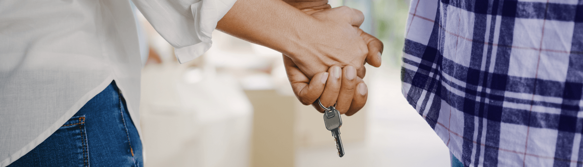 Mani incrociate che tengono le chiavi di una casa, simbolo   
di un affitto a lungo termine