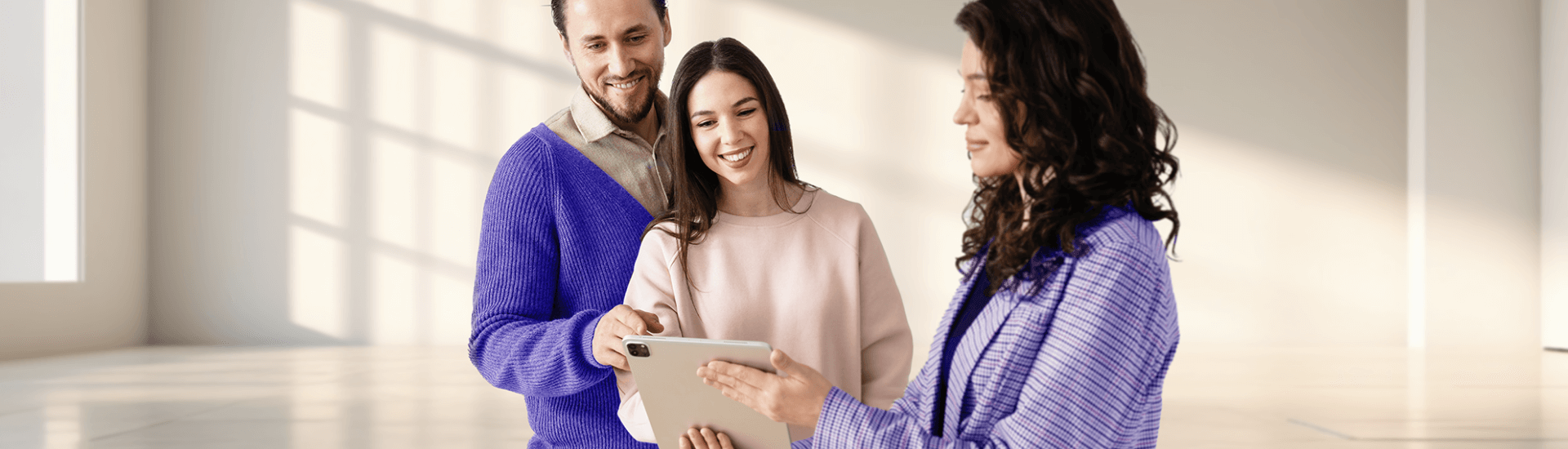 Coppia di proprietari che consulta un agente immobiliare davanti a un tablet per trovare un inquilino affidabile