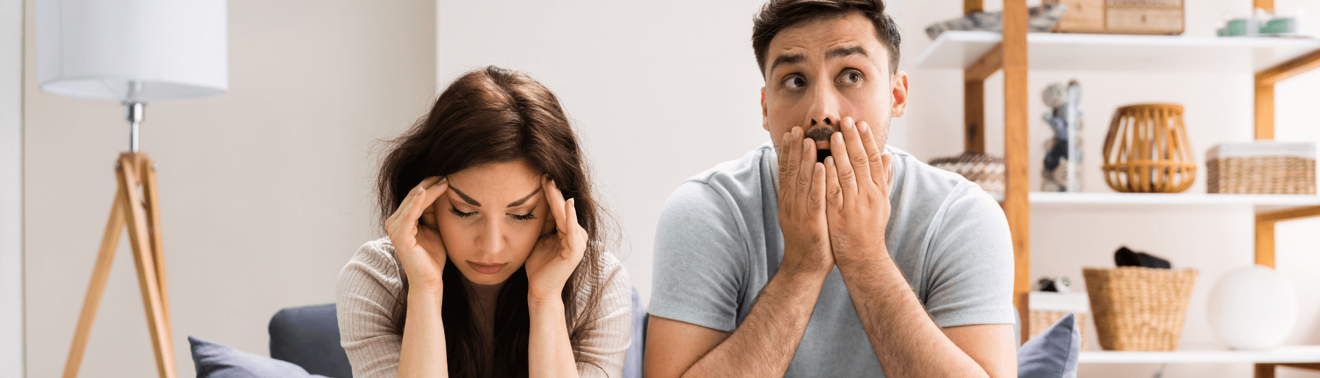 Uomo e donna preoccupati all’interno di un appartamento, simbolo delle incertezze legate ai rischi del contratto di affitto transitorio