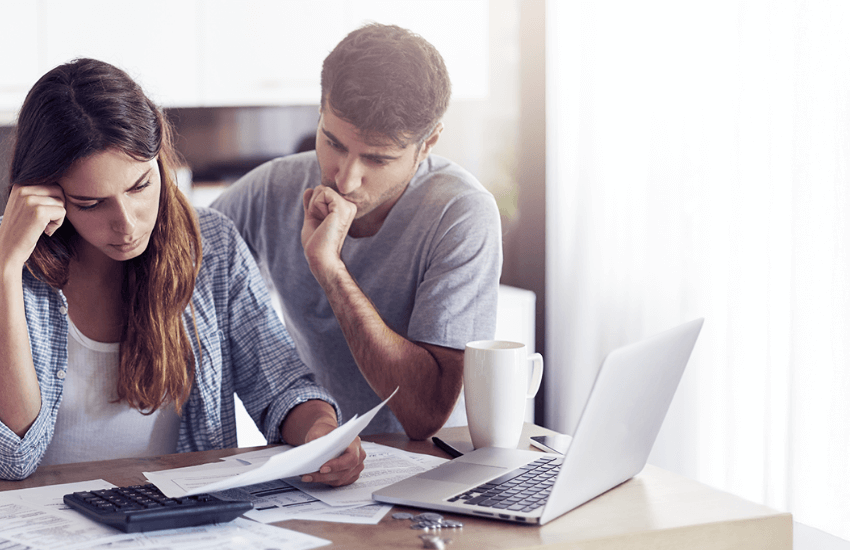 Coppia preoccupata che esamina documenti di affitto per problemi con un inquilino moroso